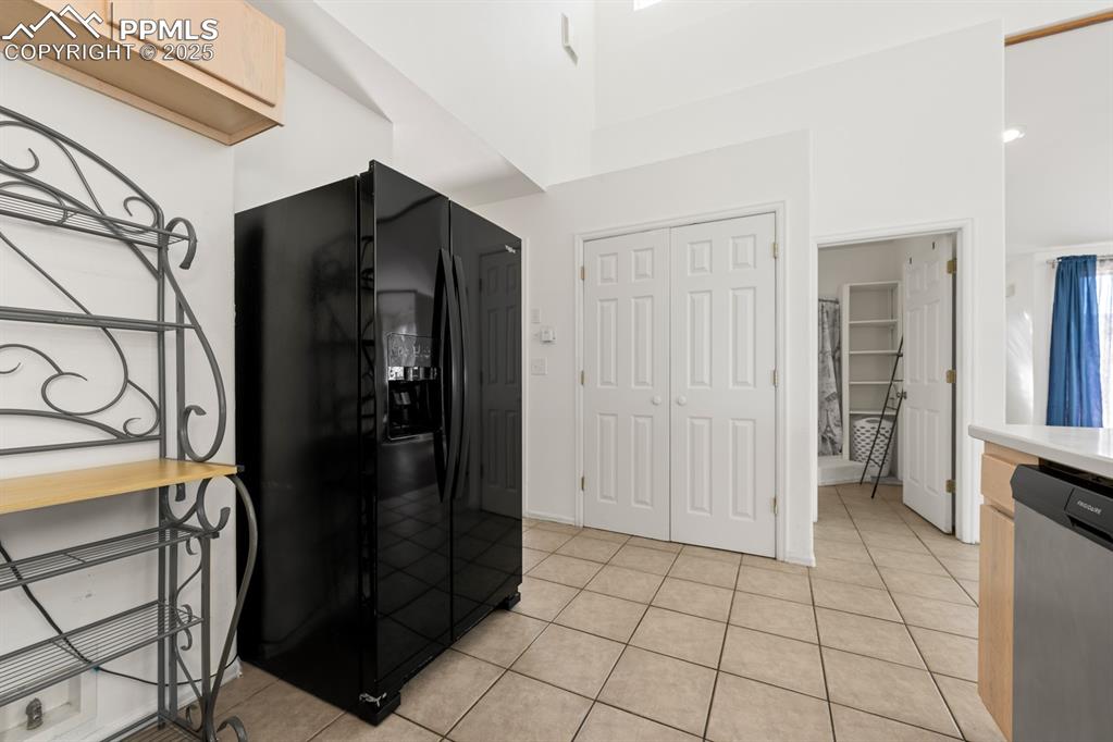 Image 41 of 50: Kitchen with black refrigerator with ice dispenser, dishwasher, light tile