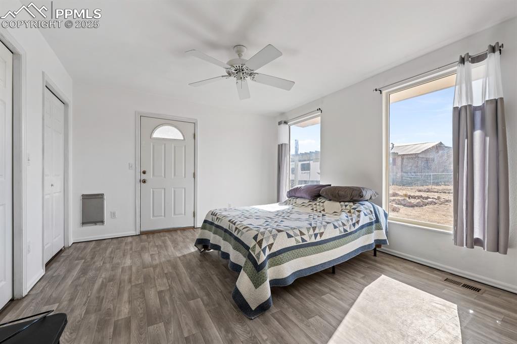 Image 43 of 50: Bedroom with wood finished floors, a ceiling fan, and a closet