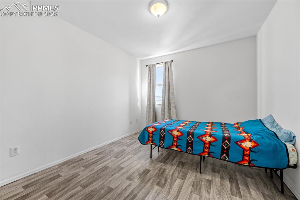 Image 46 of 50: Bedroom with wood finished floors and baseboards