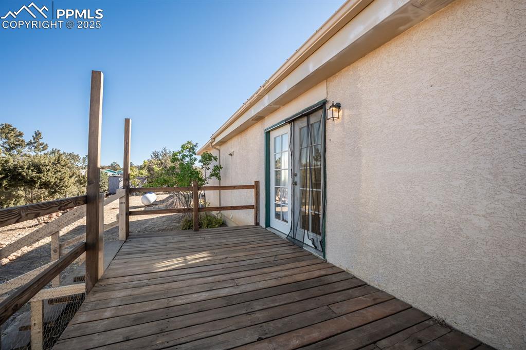 Image 49 of 50: Wooden deck with french doors