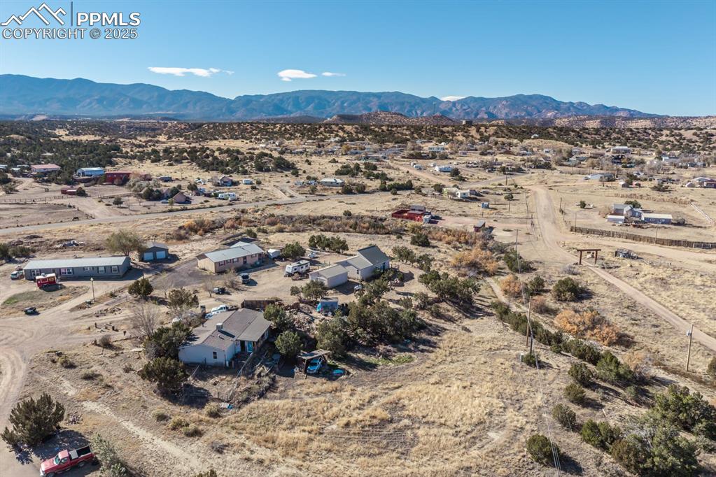 Image 9 of 50: Aerial view of sparsely populated area featuring a desert landscape and a m