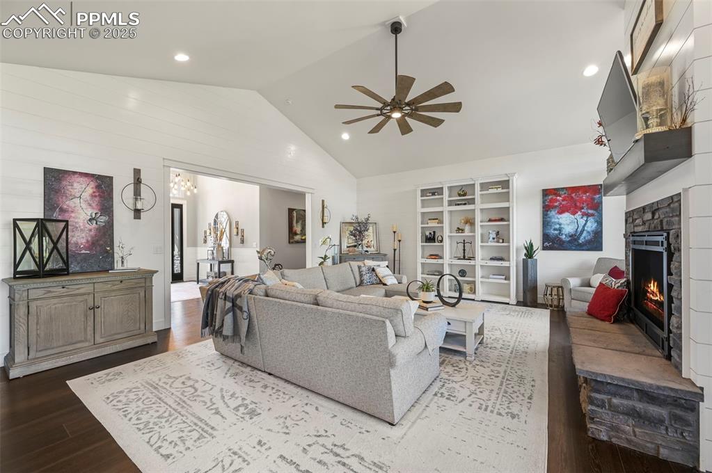 Image 8 of 50: Shiplap paneling accents the stone fireplace, while hand-picked lighting fi