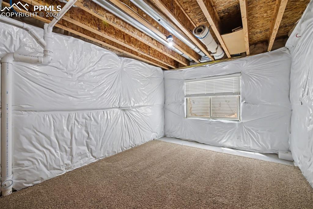 Image 39 of 42: Unfinished basement area which was utilized as a storage room.