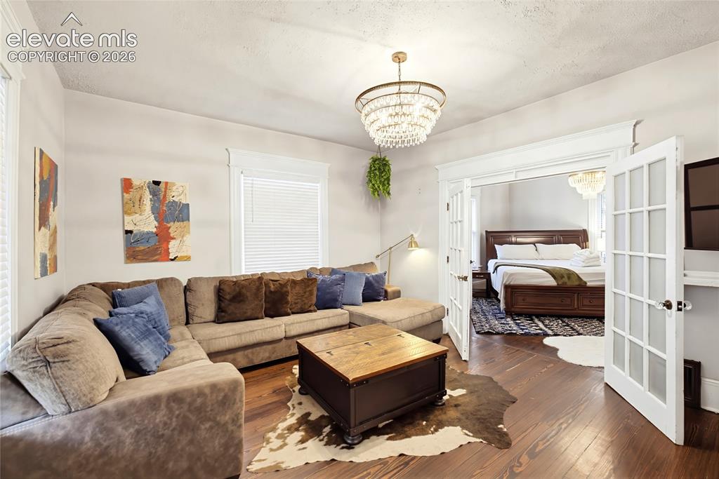 Image 12 of 50: Hardwood flooring, decorative chandelier, white trim, recessed entry, and F