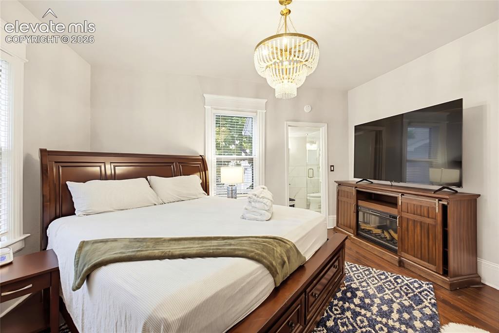 Image 16 of 50: Recessed lighting, wood-finish flooring, and a decorative chandelier