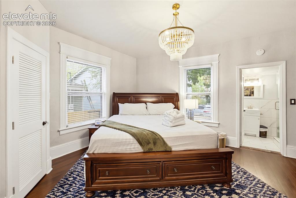Image 17 of 50: Hardwood flooring, white louvered closet door, decorative ceiling light fix
