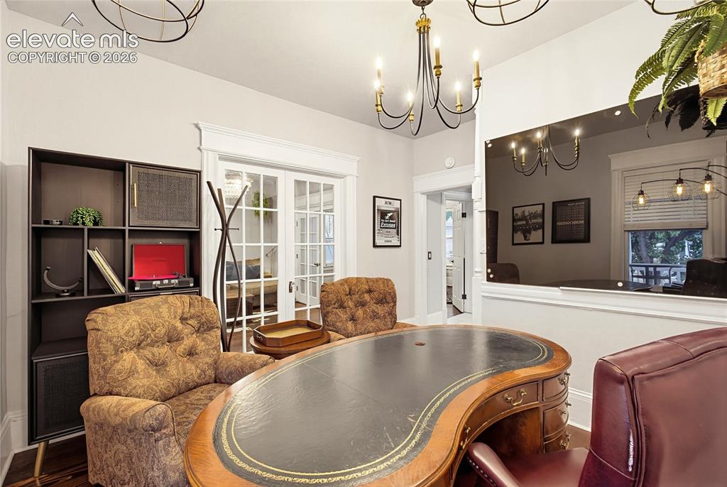 Image 21 of 50: Room featuring a built-in shelving unit, double French doors, wood-finish f