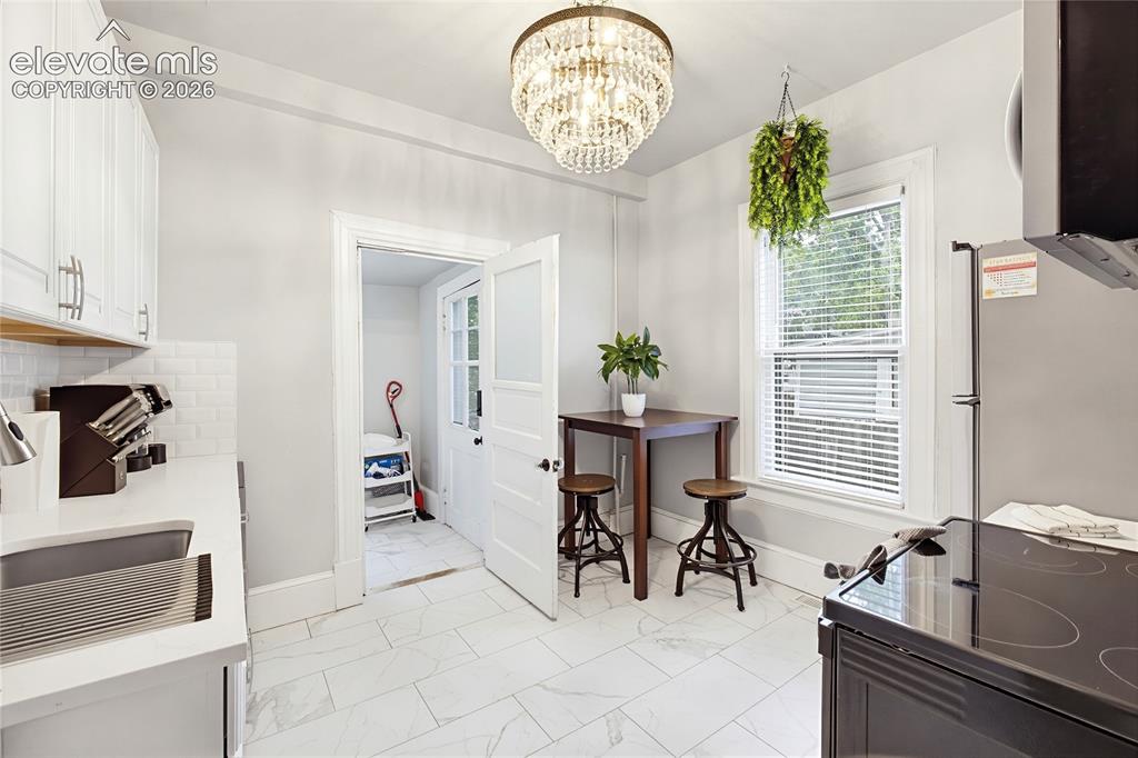 Image 23 of 50: White shaker-style cabinetry with brushed nickel pulls, subway tile backspl