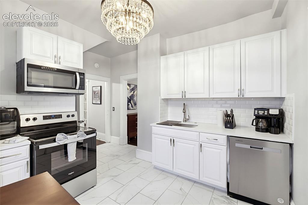 Image 26 of 50: White shaker-style cabinetry, stainless steel appliances, white subway tile