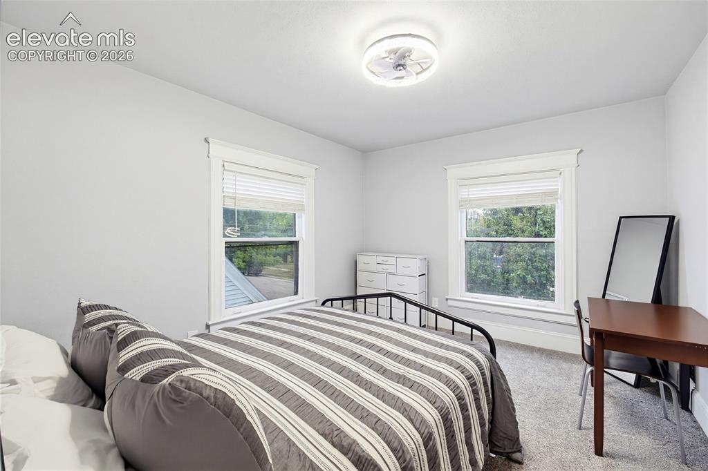 Image 30 of 50: Two windows with white trim, ceiling-mounted light fixture, and light-color