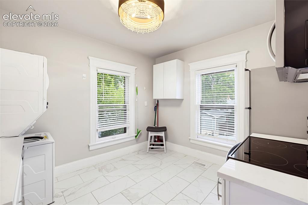 Image 34 of 50: White tile flooring, dual windows with white trim, built-in white cabinetry