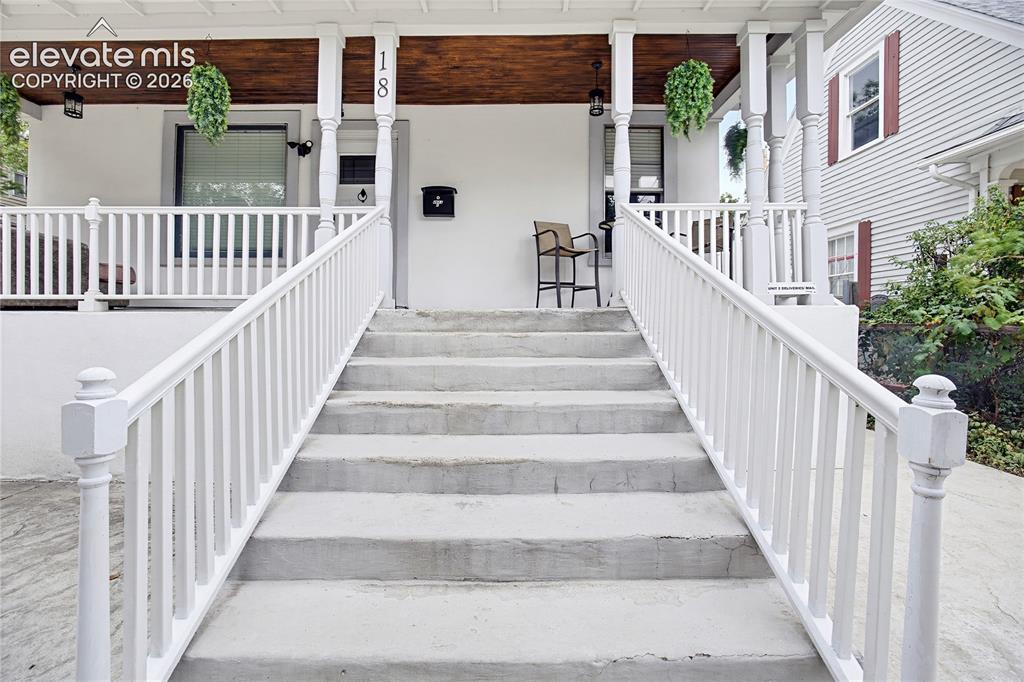 Image 4 of 50: Front porch with turned columns and wood-finish ceiling