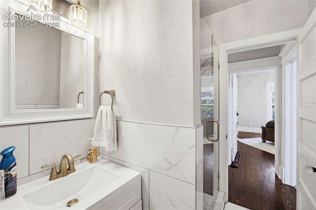 Image 40 of 50: White vanity with an integrated rectangular sink, brass-finish faucet, fram