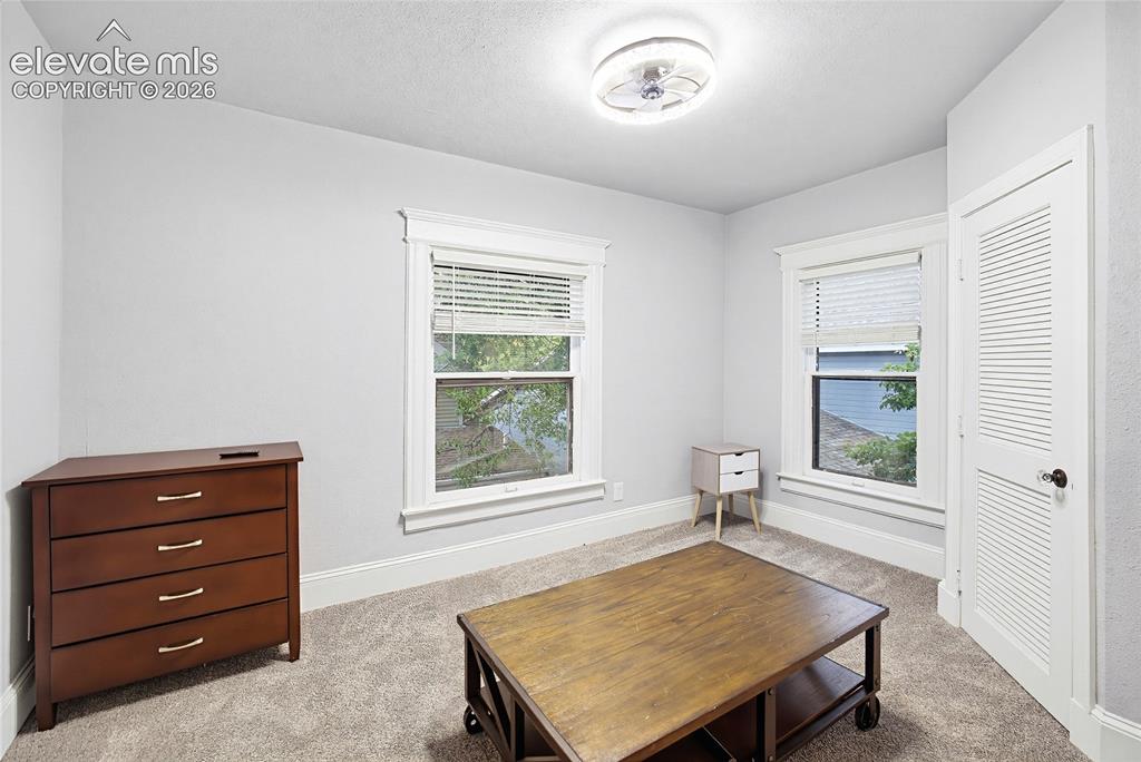Image 42 of 50: Neutral wall finishes, carpeted flooring, two windows with blinds, ceiling