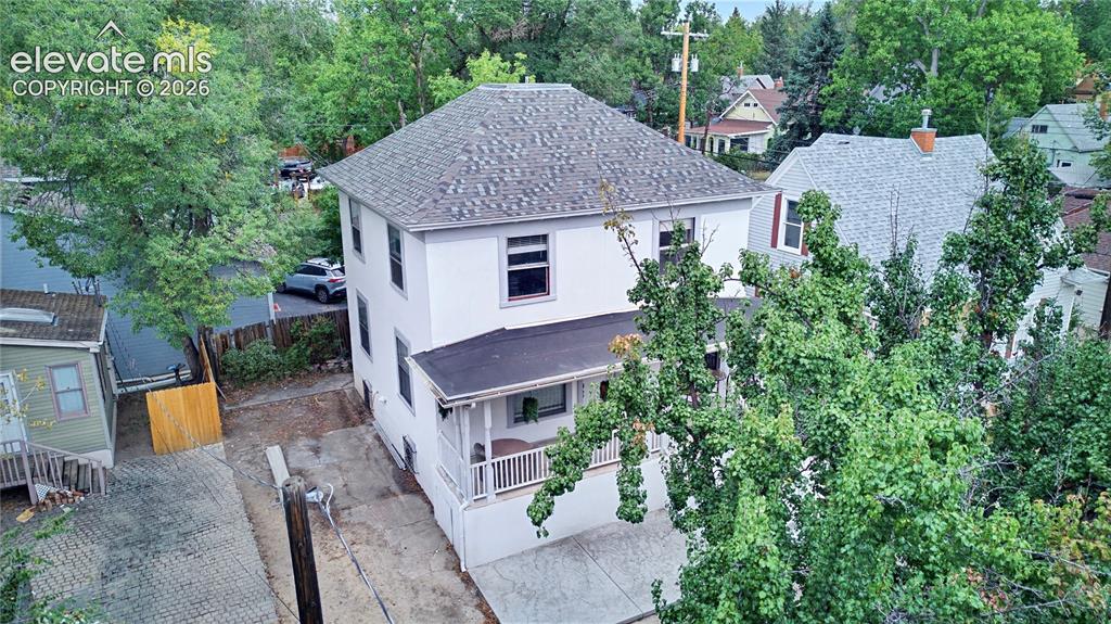 Image 6 of 50: Two-story exterior with a shingle roof, covered porch, and white railings