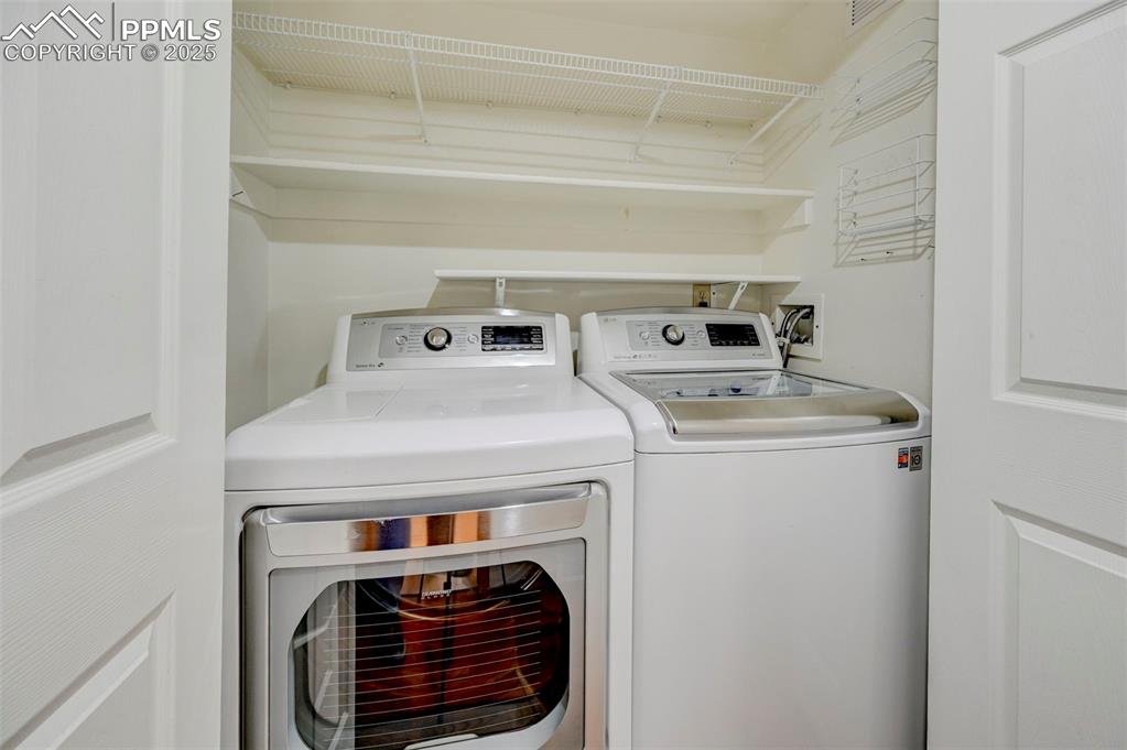 Image 13 of 34: Washroom featuring washing machine and clothes dryer