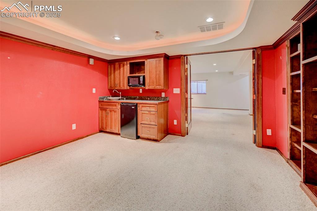 Image 19 of 34: Kitchen with dishwasher, black microwave, light carpet, recessed lighting, 