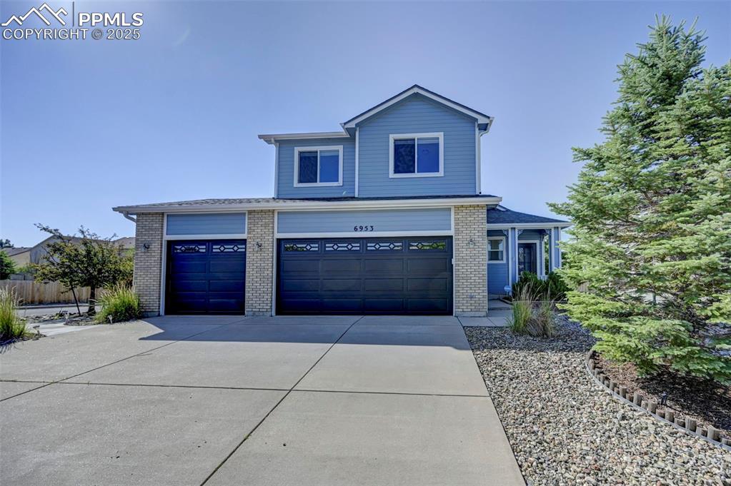 Image 2 of 34: View of front of property with concrete driveway, brick siding, and a garag