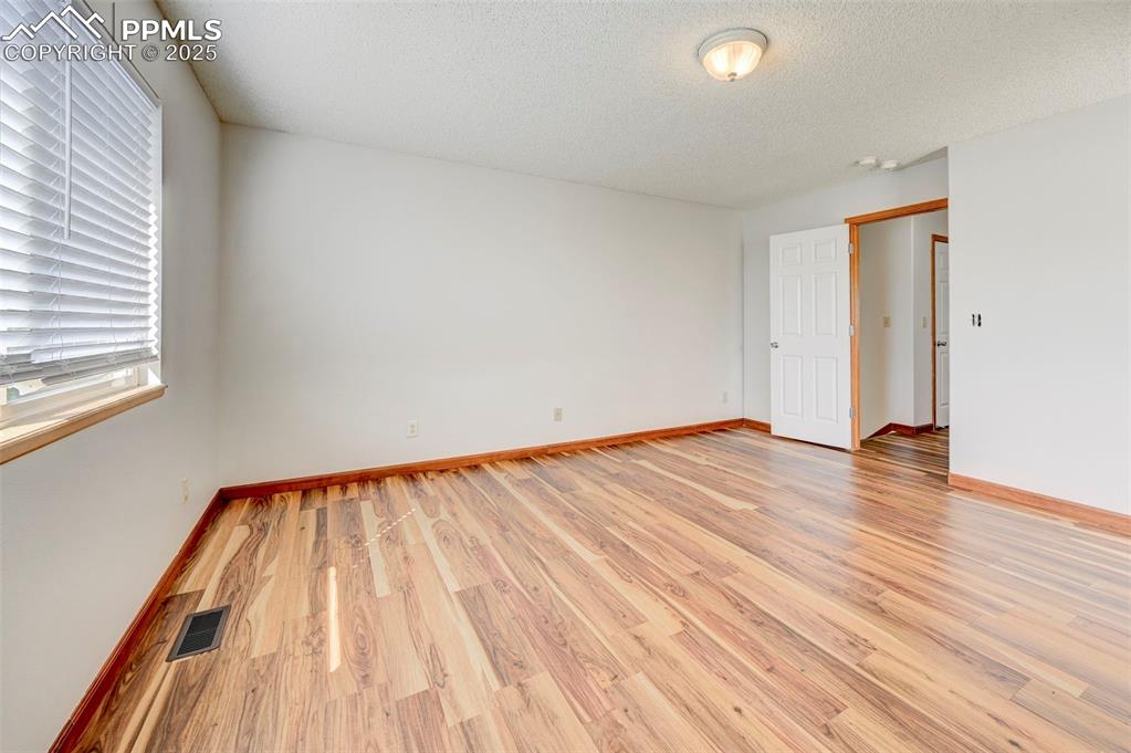 Image 21 of 34: Unfurnished room featuring light wood-style flooring, healthy amount of nat