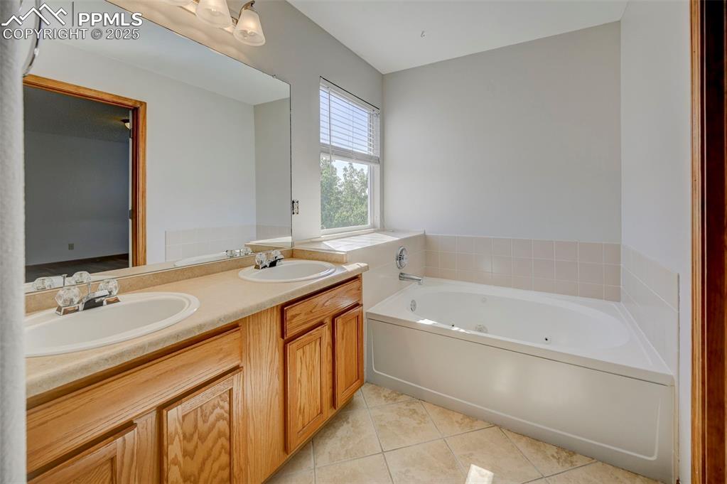 Image 23 of 34: Full bath with a jetted tub, tile patterned flooring, and double vanity