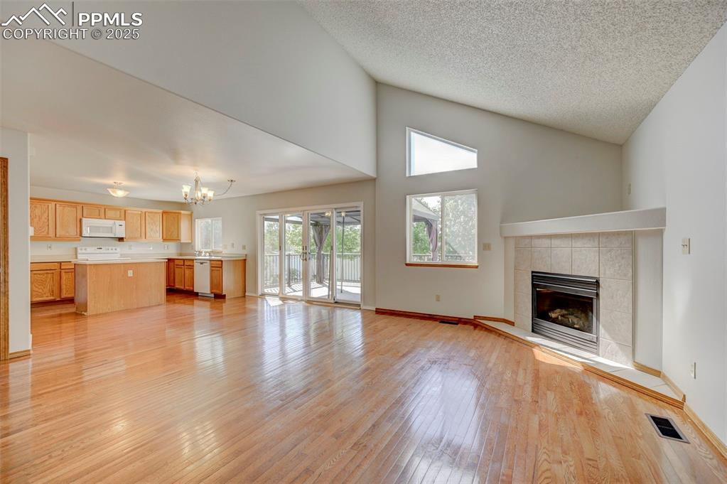 Image 4 of 34: Unfurnished living room featuring a chandelier, light wood-type flooring, a