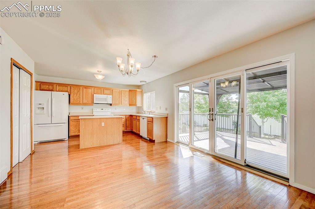 Image 7 of 34: Kitchen featuring white appliances, a chandelier, light countertops, a cent