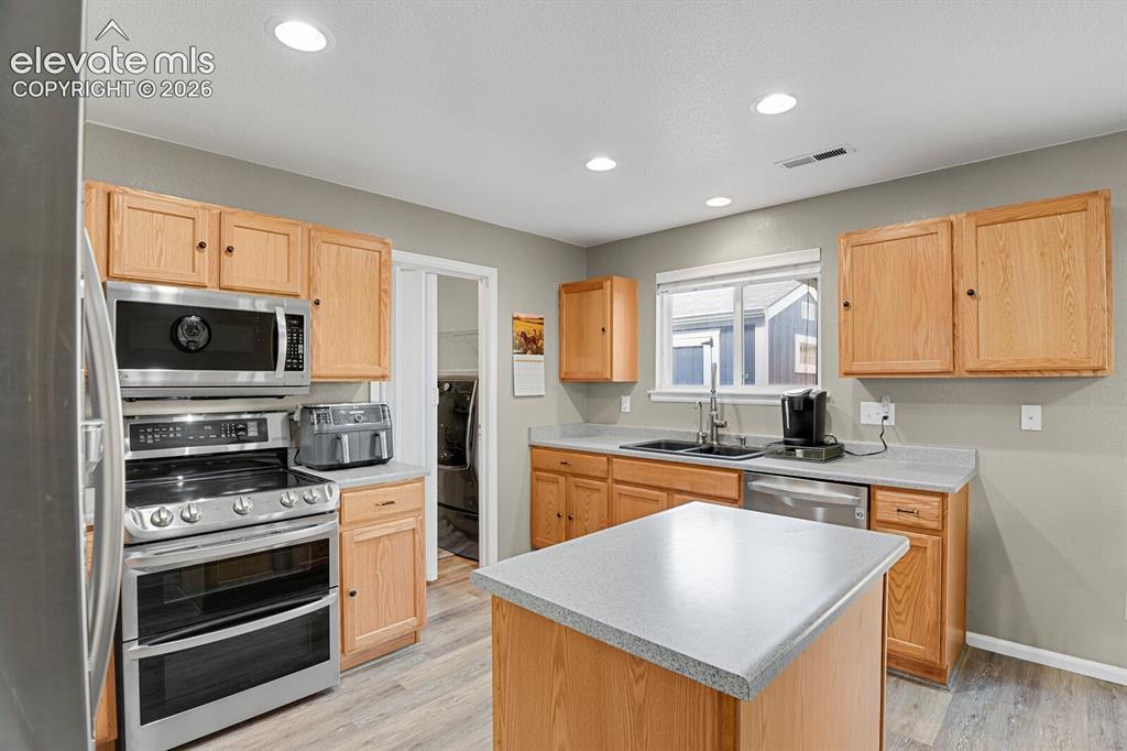 Image 13 of 31: Open-concept kitchen and dining area featuring wood- cabinetry, nice floori