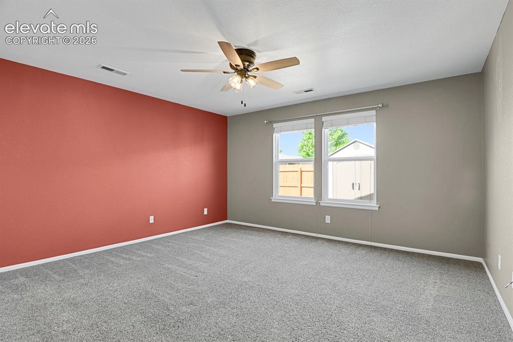 Image 23 of 31: Second bedroom featuring light blue walls, gray carpet, nice window and a c