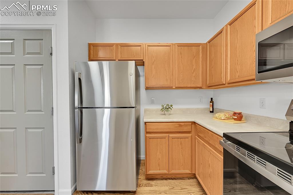 Image 12 of 31: Kitchen featuring appliances with stainless steel finishes, light counterto