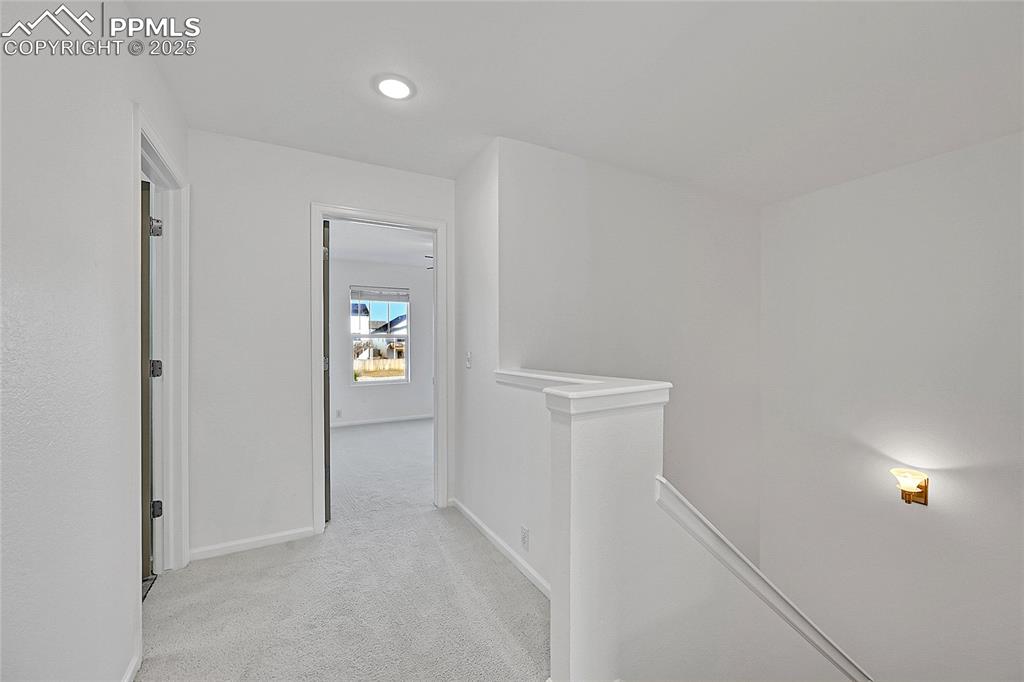 Image 15 of 31: Corridor with an upstairs landing, light carpet, and recessed lighting