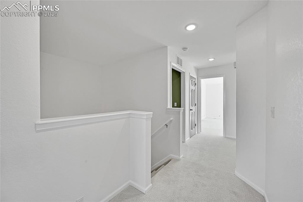Image 17 of 31: Corridor featuring an upstairs landing, light carpet, and recessed lighting