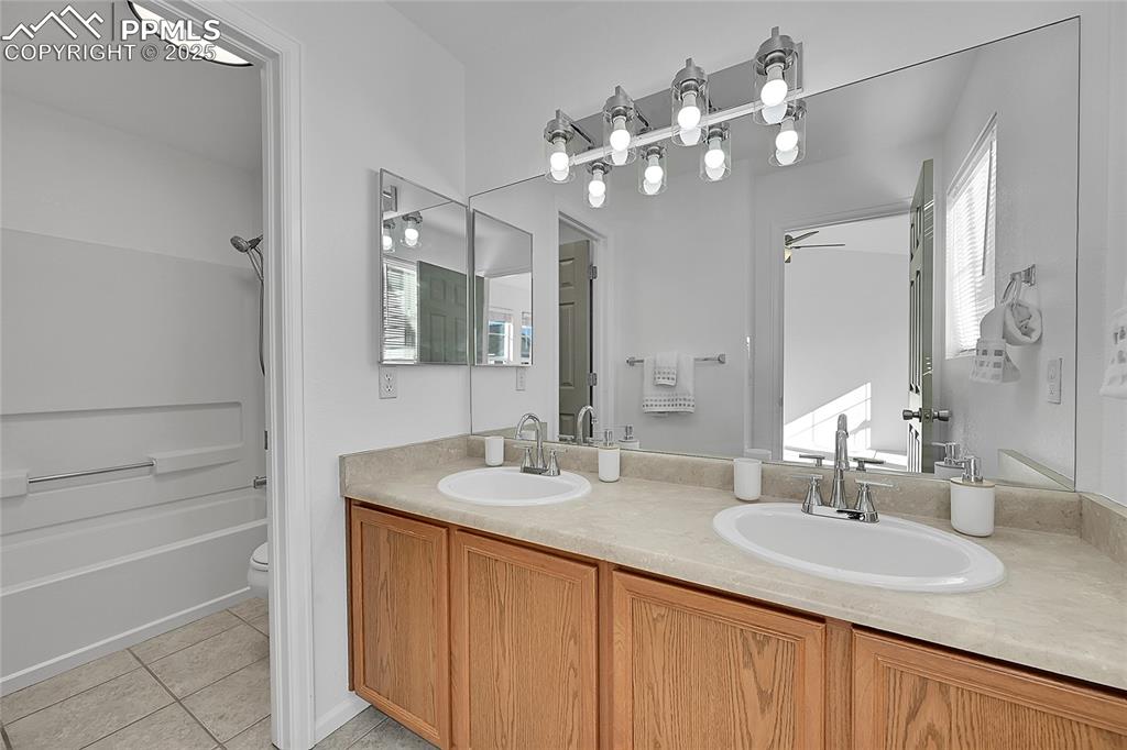 Image 19 of 31: Bathroom featuring double vanity, light tile patterned flooring, bathtub / 
