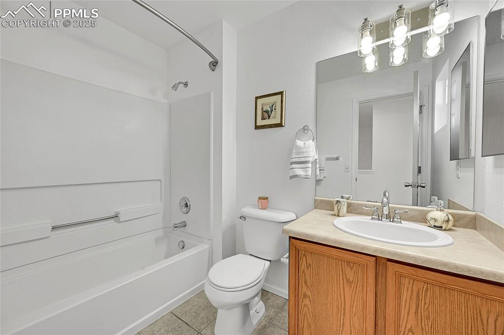Image 22 of 31: Full bath featuring shower / bathtub combination, vanity, and light tile pa