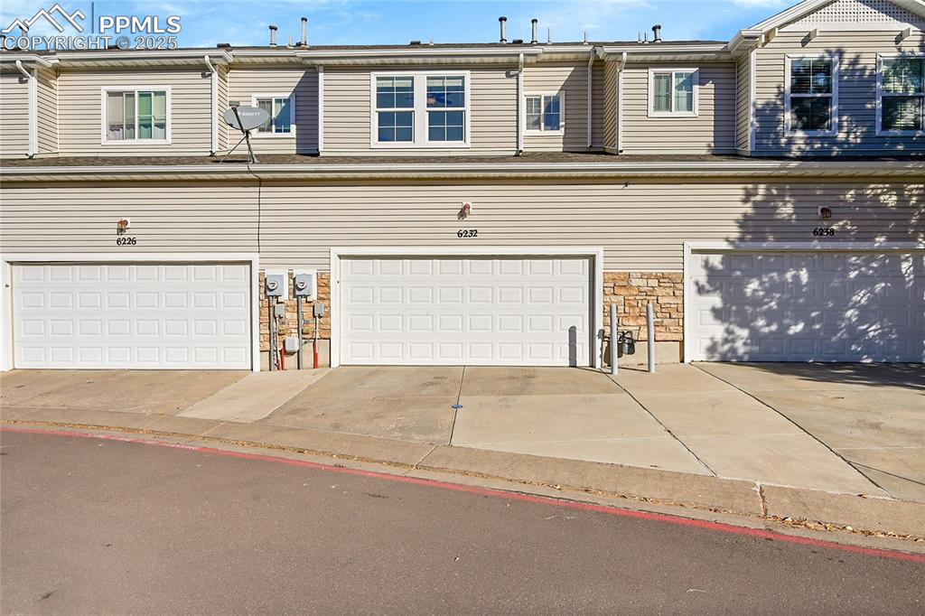 Image 26 of 31: View of front of home with stone siding and driveway