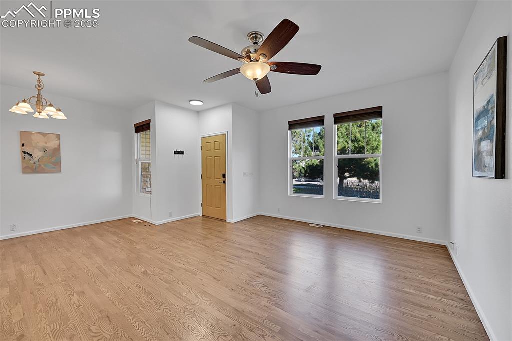 Image 5 of 31: Empty room featuring light wood-type flooring, a chandelier, and a ceiling 