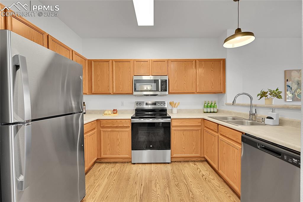 Image 9 of 31: Kitchen featuring stainless steel appliances, light countertops, light wood