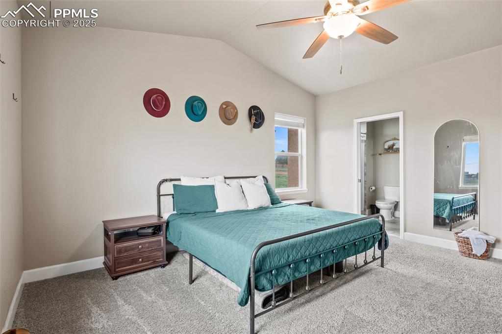 Image 25 of 30: Bedroom featuring carpet floors, vaulted ceiling, arched walkways, baseboar