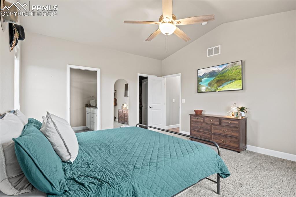 Image 26 of 30: Bedroom with lofted ceiling, carpet floors, baseboards, ceiling fan, and ar