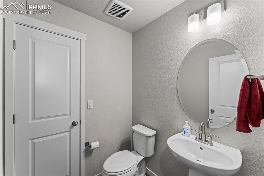 Image 16 of 46: 1/2 bath right outside office and entry way on main floor