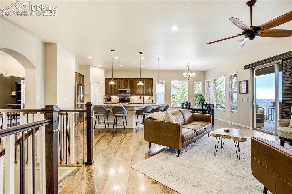 Image 12 of 48: Open-concept living space featuring hardwood flooring, a kitchen with dark
