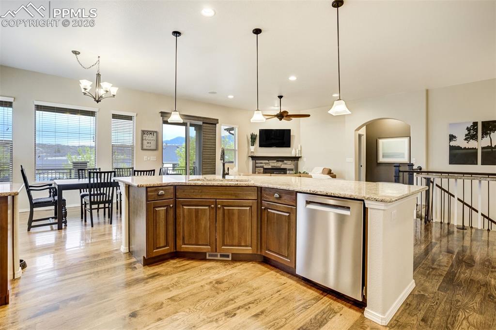 Image 16 of 48: Spacious kitchen featuring a large island with granite countertops, rich wo