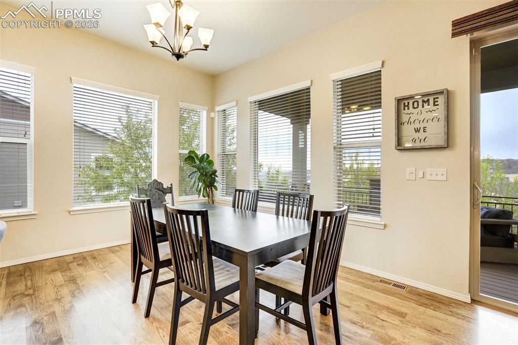 Image 17 of 48: Dining area featuring multiple large windows, hardwood flooring, and a slid