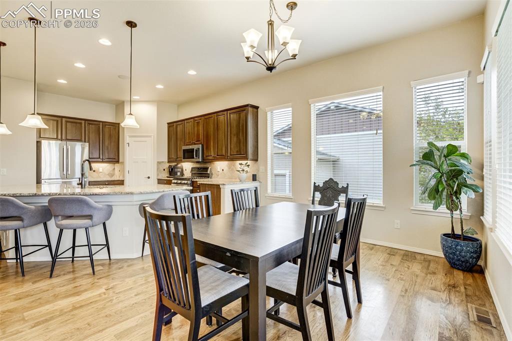 Image 18 of 48: Kitchen featuring hardwood flooring, dark wood cabinetry, stainless steel a