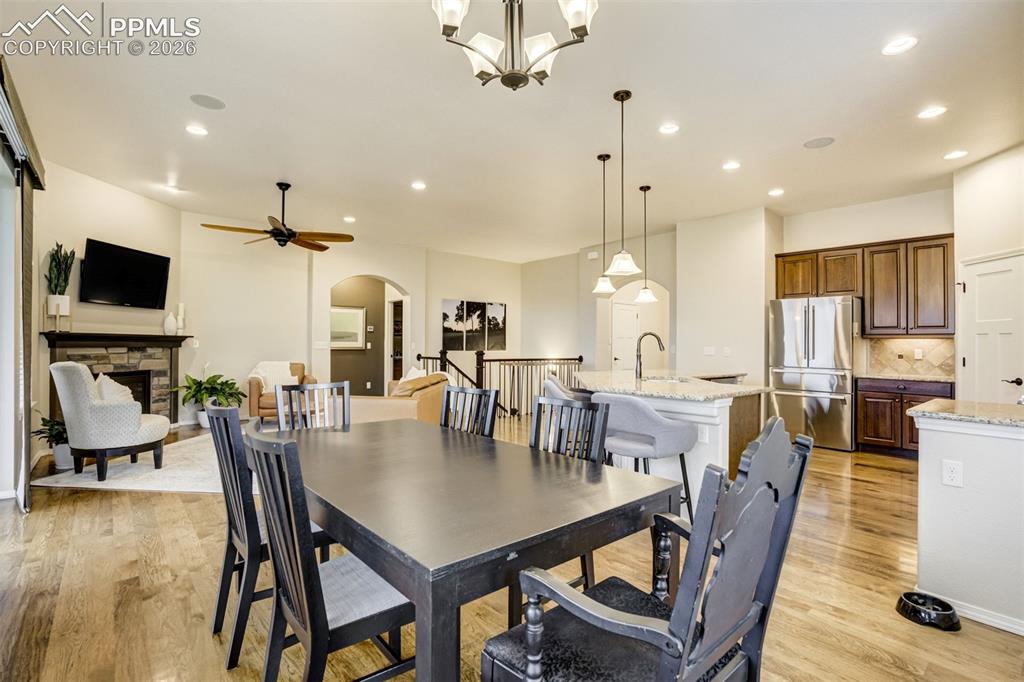 Image 20 of 48: Open-concept floor plan featuring hardwood flooring, a stone-faced fireplac