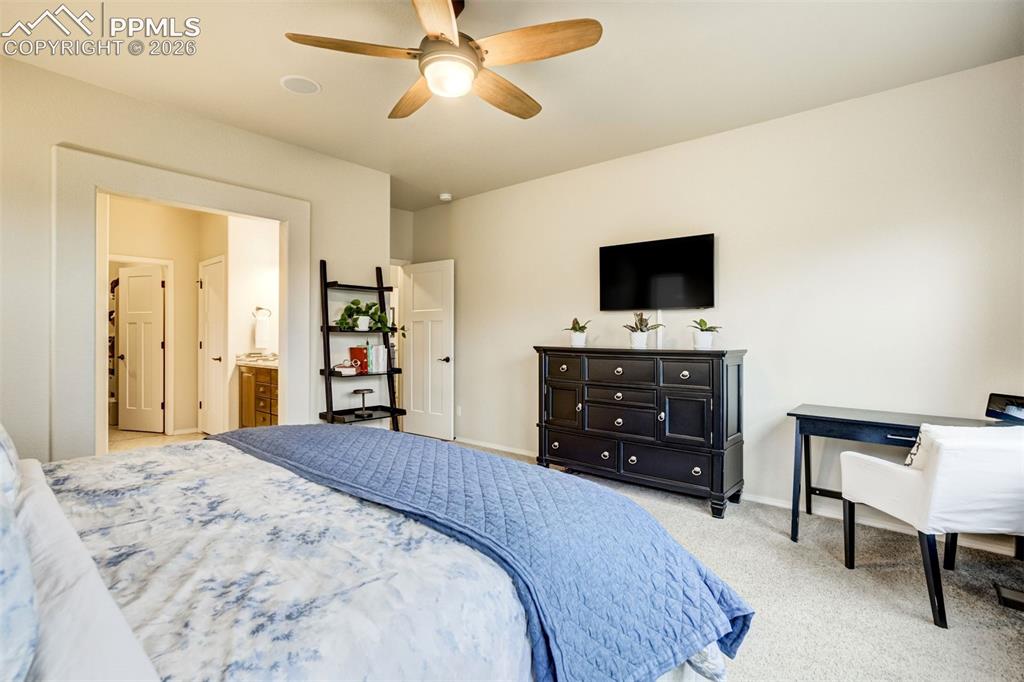 Image 28 of 48: Carpeted bedroom featuring a ceiling fan with light fixture, ample wall spa