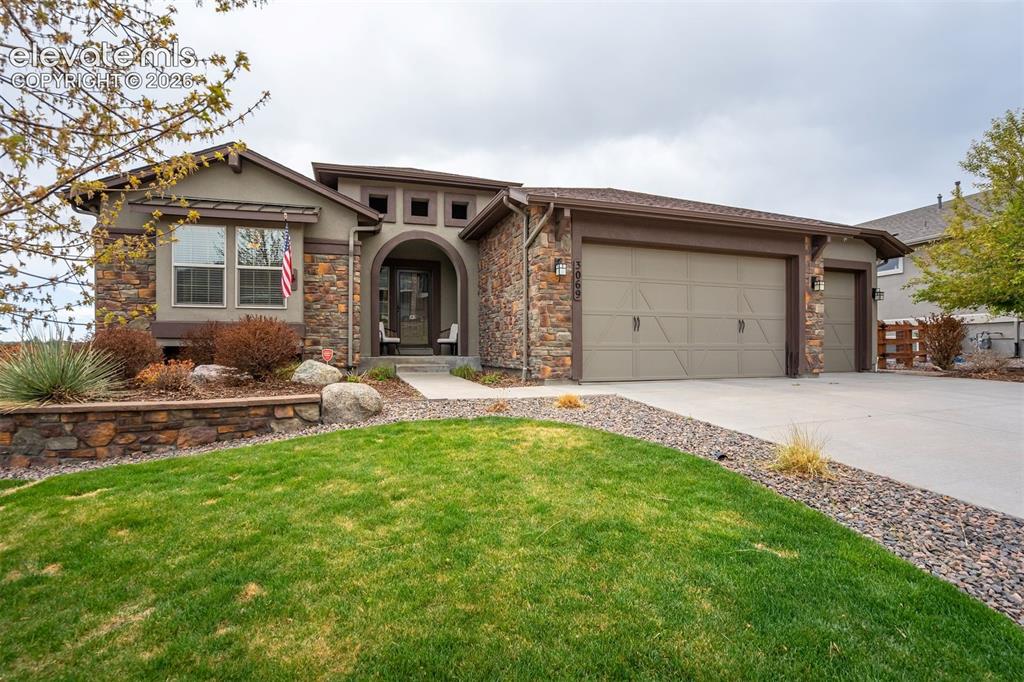 Image 3 of 48: Contemporary ranch-style residence featuring a stone and stucco exterior, a