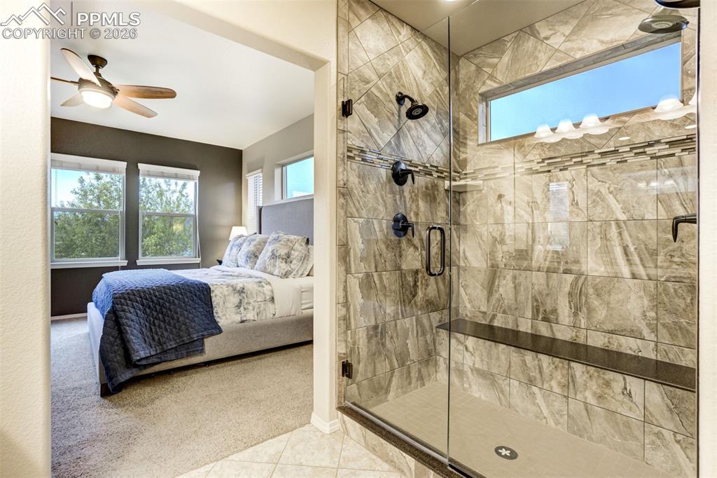 Image 31 of 48: Frameless glass shower enclosure featuring large format stone-finish wall t