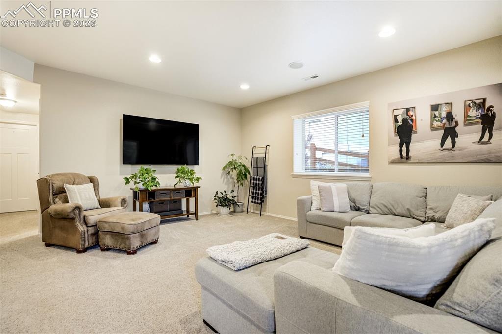 Image 36 of 48: Spacious carpeted living area featuring recessed lighting, a built-in speak