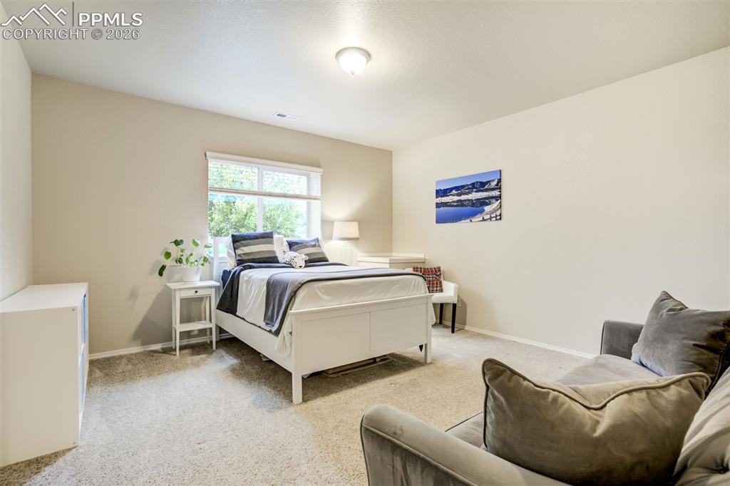 Image 41 of 48: Basement Bedroom 1 with a large window and neutral-toned walls