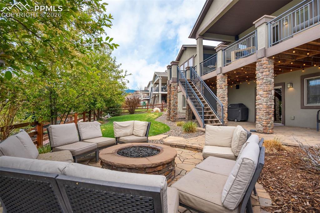 Image 47 of 48: Outdoor patio featuring a stone fire pit, flagstone pavers, a multi-level d